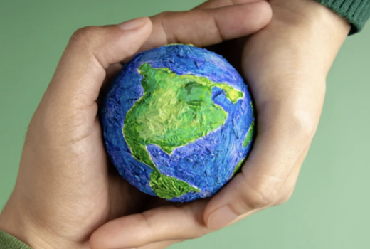 Hands holding the Earth globe, representing a commitment to sustainable roofing and environmental responsibility.