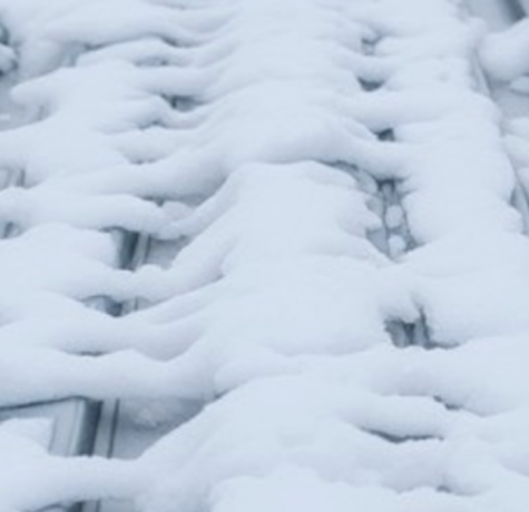 Frozen ice on a roof during winter, highlighting potential roofing issues.