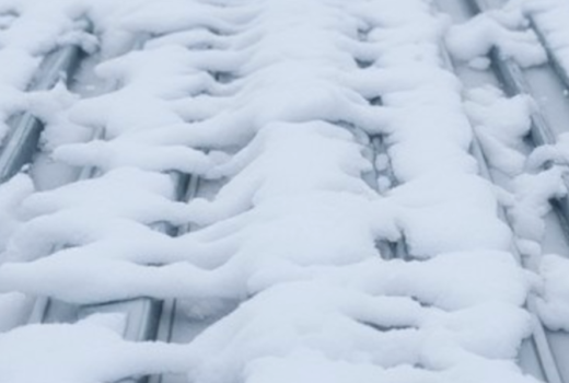 Frozen ice on a roof during winter, highlighting potential roofing issues.